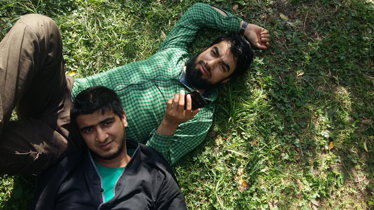     Photographer unknown, Hizbul Mujahedeen commander Dawood Sheikh (bottom right) and a friend take a rest during a picnic, 2014. From the collection of Nathaniel Brunt

