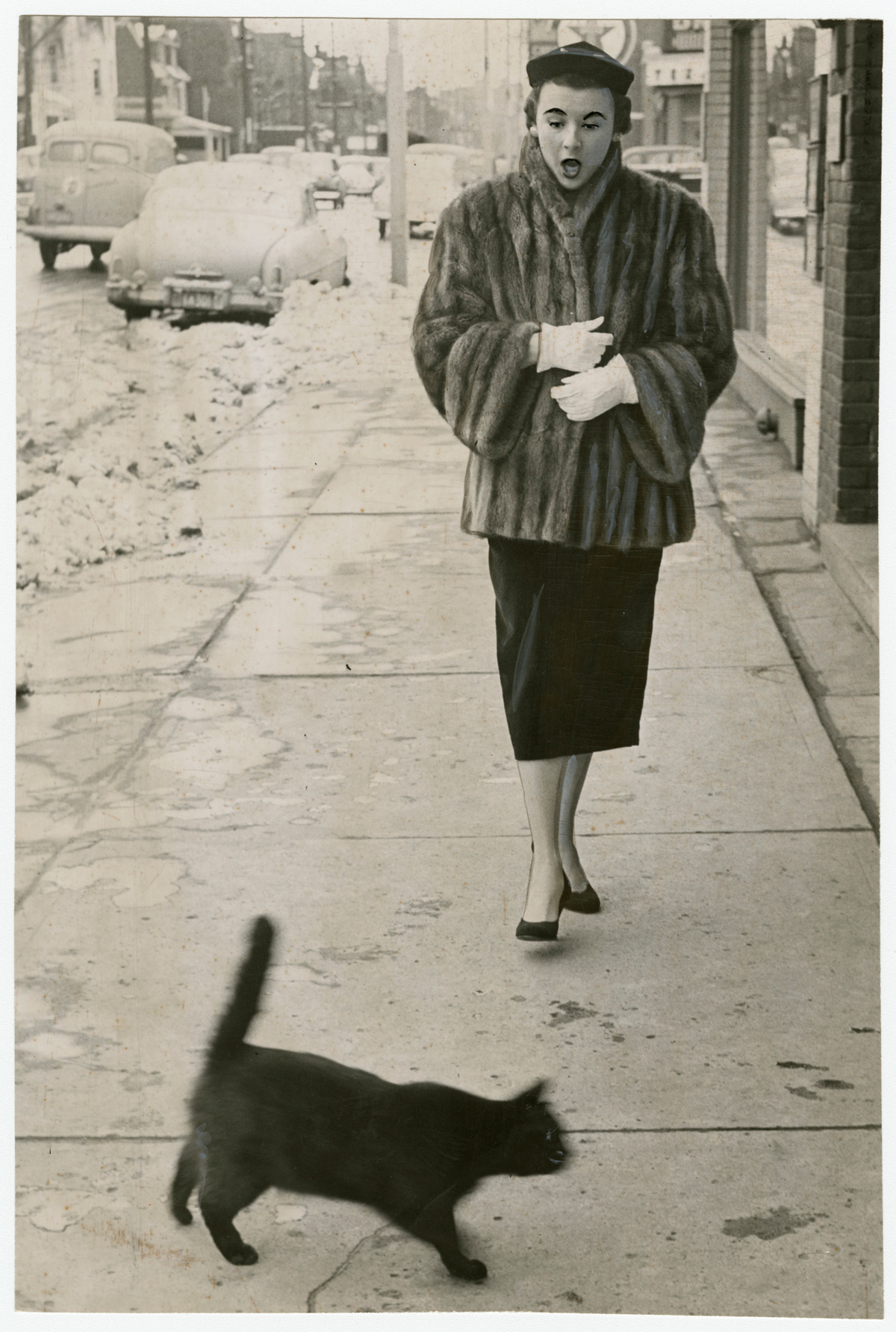     Unidentified photographer, To have a black cat cross your path at any time is unfortunate, but on Friday the 13th – oh, my! – which is just what Jean Craig said, 1953. Gelatin silver print, 9 x 6&#8243;. Gift of The Globe and Mail newspaper to the Canadian Photography Institute of the National Gallery of Canada.

