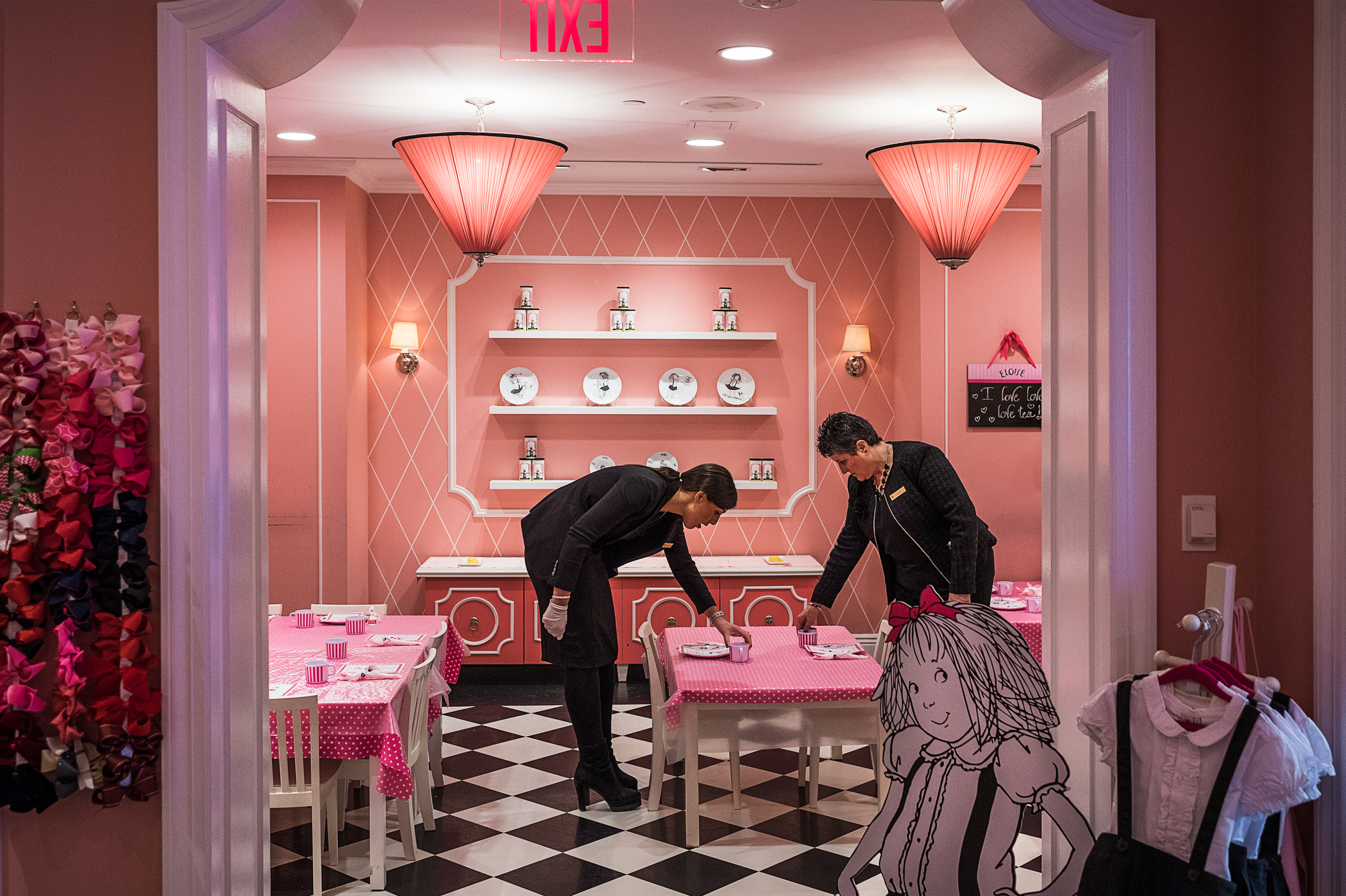    Aaron Vincent Elkaim, Laurence Ledanois, a staff member of 19 years (right) arranges tables with Jessica Azoulai for tea time at the Eloise Boutique at The Plaza, a Fairmont managed hotel, in New York., 2016. Courtesy of NAMARA represents.

