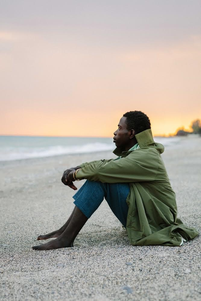     Neil-Anthony Watson, Alieu Kebbeh, a migrant from Gambia sits on the shores of Calabria, 2019

